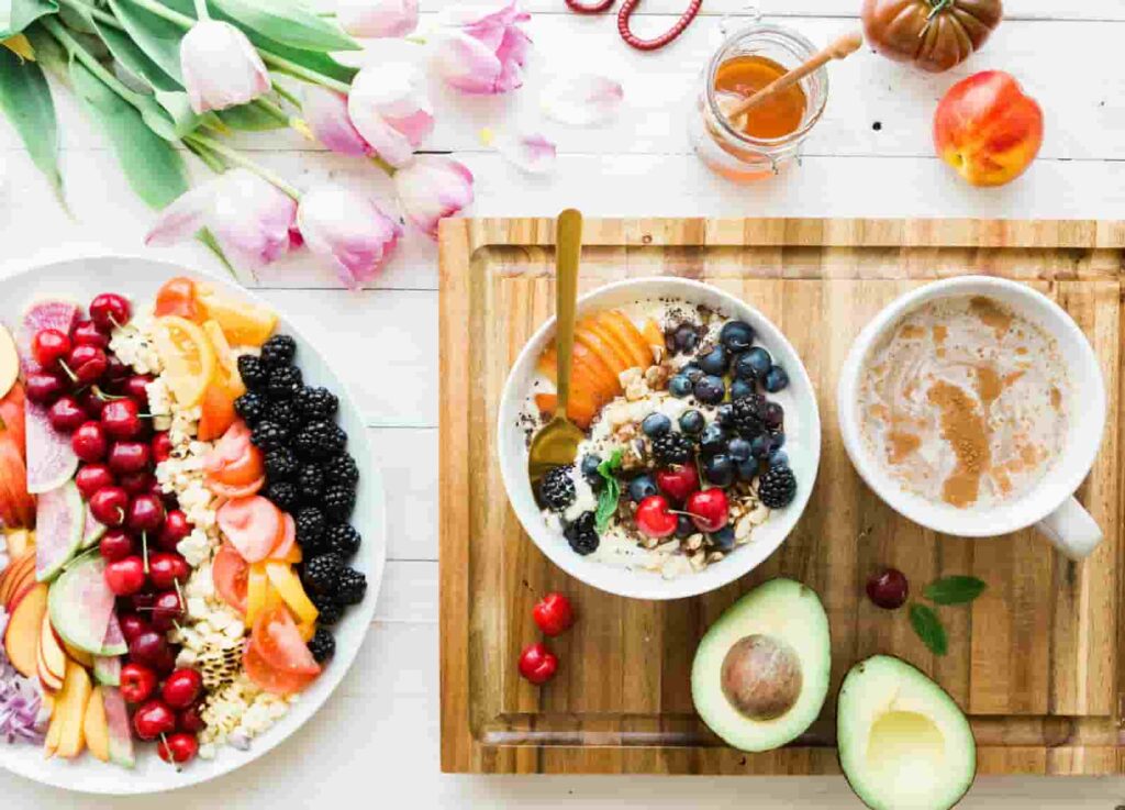 Müsli, Avocado, Kaffee und Obst auf einem Brett